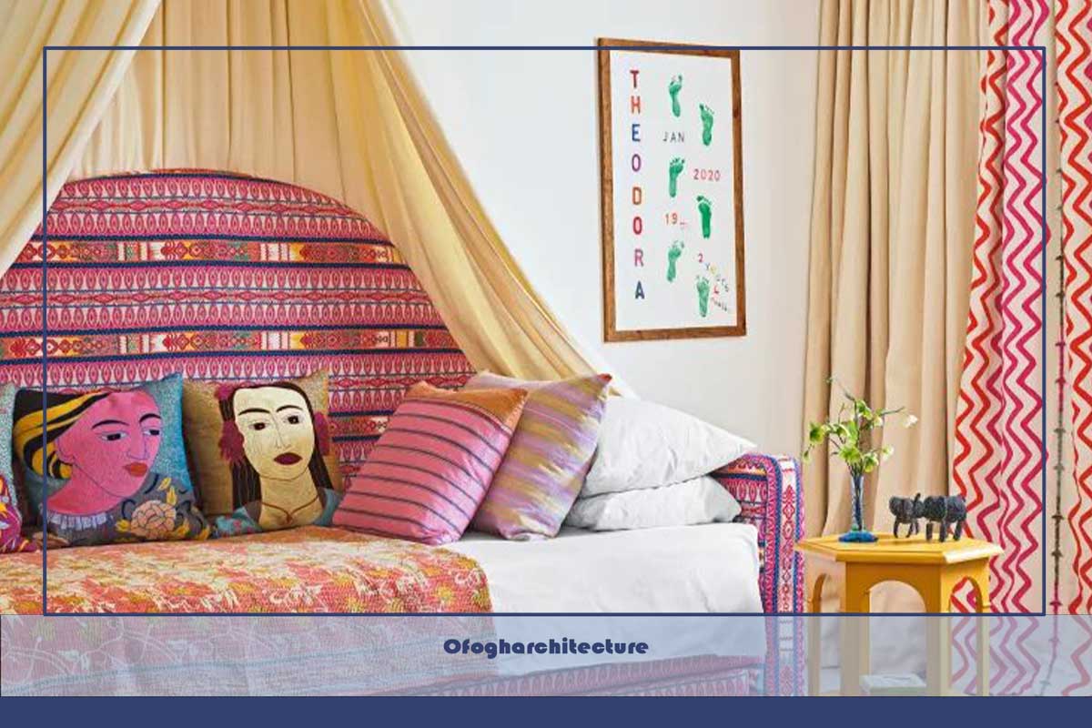 اتاق خواب رنگارنگ با مبل تختخواب‌شو منحصر به فرد با سایبان آویزان در بالا، فرش کرم، فرش طرح دار، صندلی راحتی قرمز، پرده‌های کرم، قرمز و صورتی