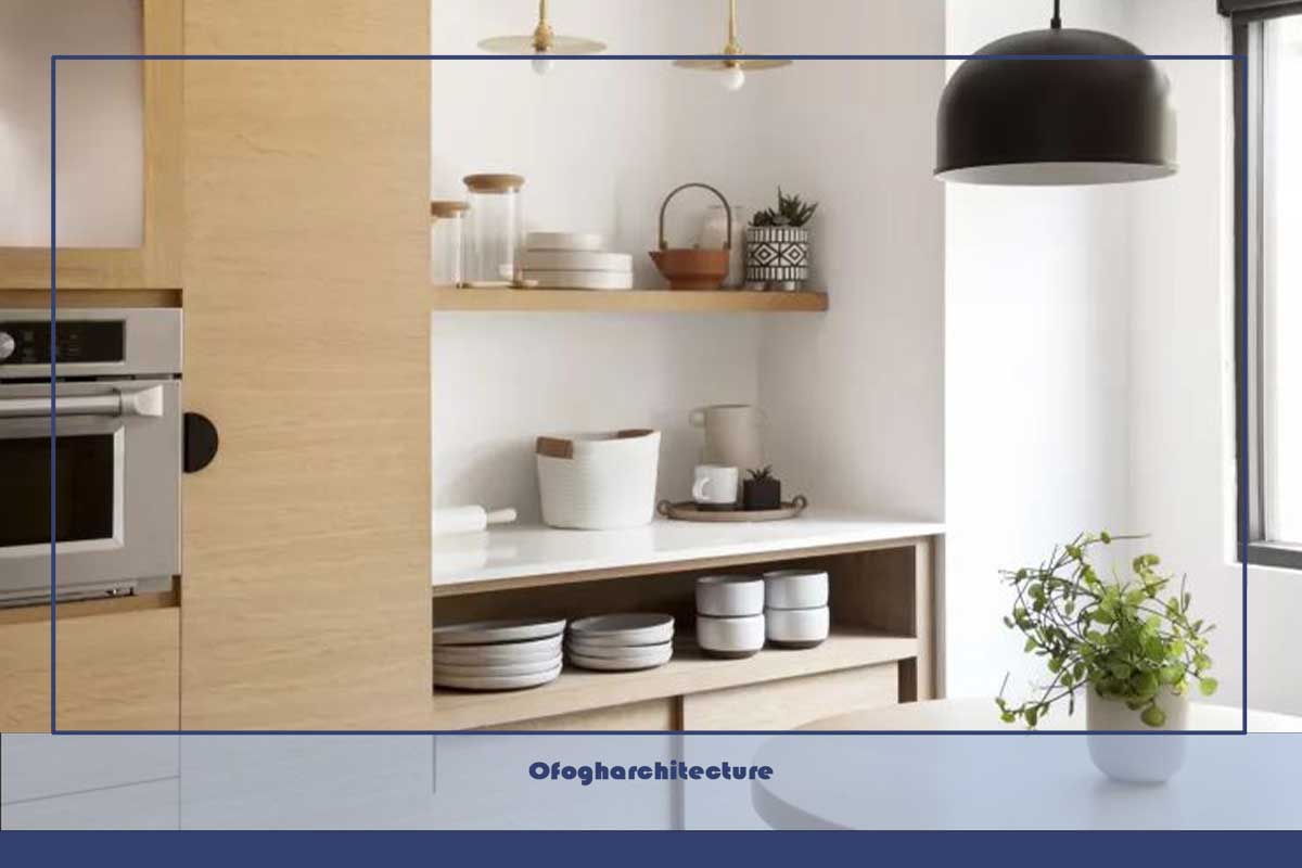 آشپزخانه چوبی سفید و بلوند سبک اسکاندیناوی با کابینت از کف تا سقف و قفسه بندی باز، چراغ‌های آویز، میز ناهار خوری گرد، چهارپایه
